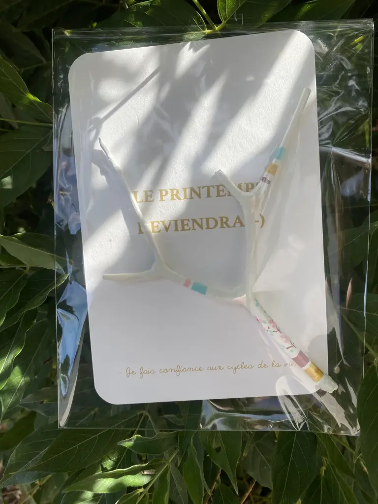 Mise en scène de la carte avec grigri mini- bâton de parole "Le Printemps reviendra" sous pochette plastique