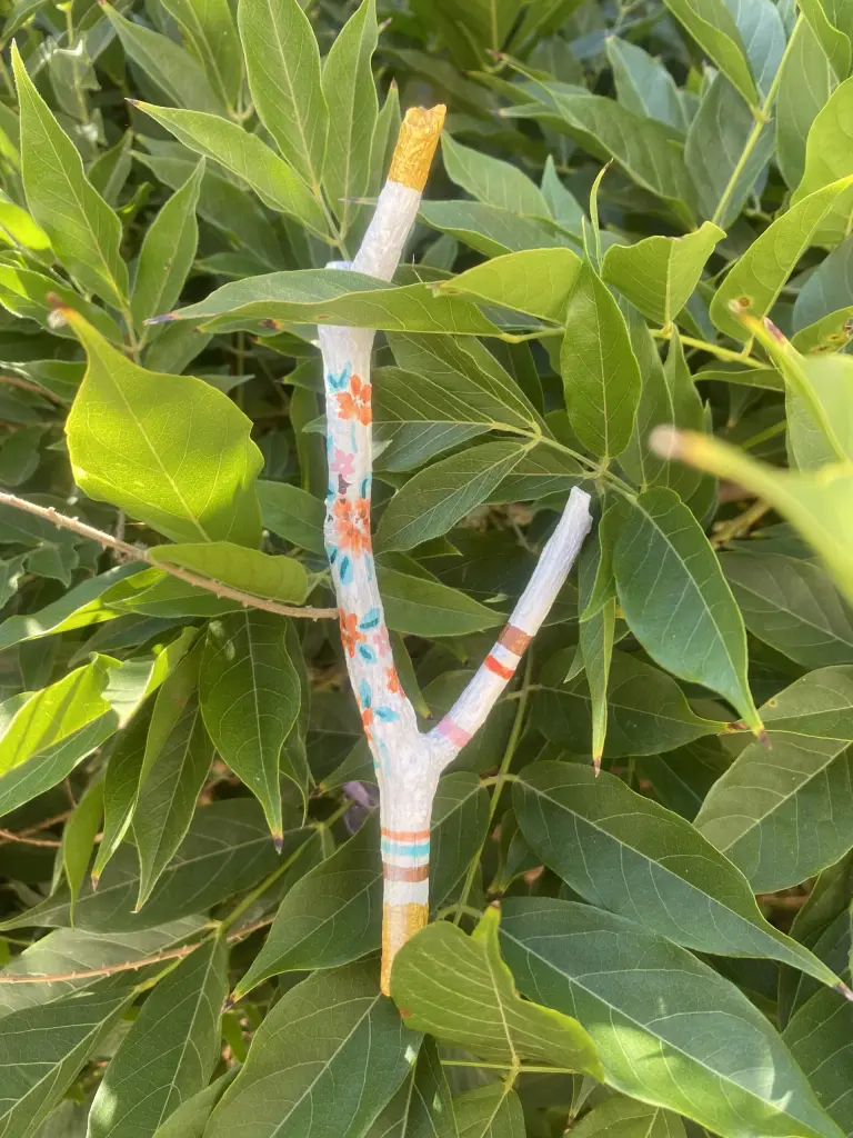 bâton avec fleurs oranger dessinées dans feuillage