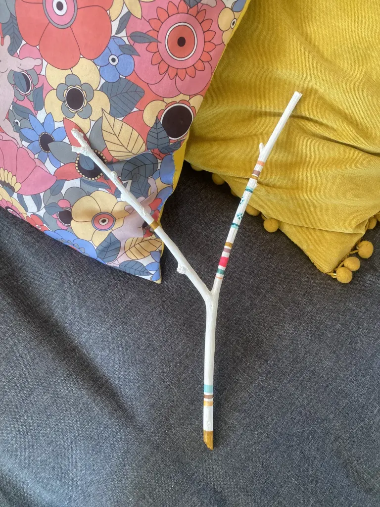 Bâton de parole comptine vue de face sur canapé avec 2 coussins